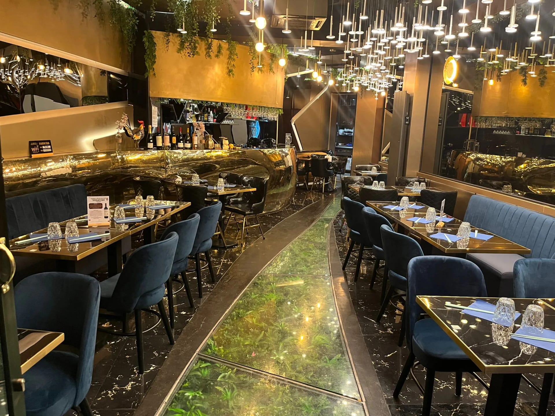 Sculpted golden bar of the Phở 98 restaurant topped with crystal chandeliers
